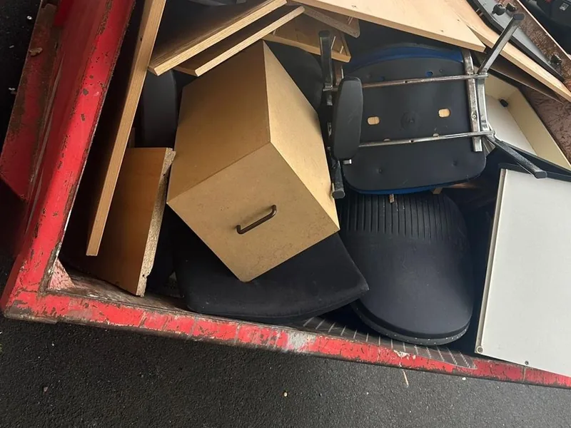 Container mit Holzplatten, Kartons und Bürostühlen