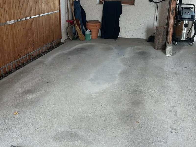 Leere Garage mit Holztor nach der Entrümpelung