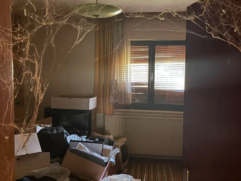Lange unbewohnter Raum mit Kartons, Gerümpel und Spinnweben
