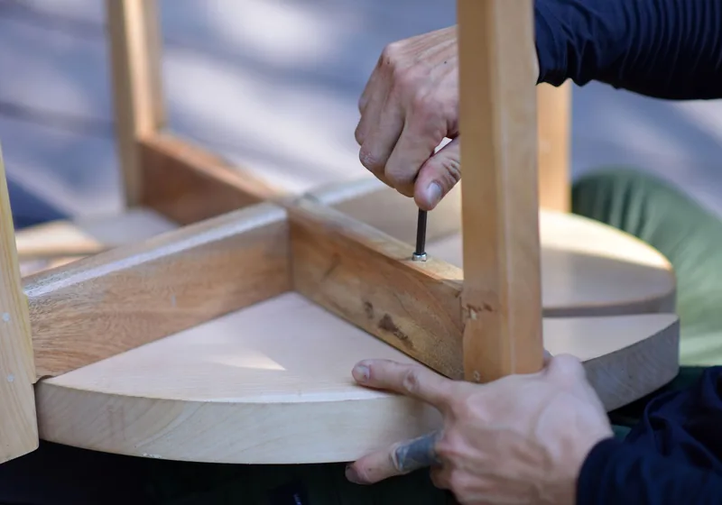Hände montieren ein Tischgestell aus Holz