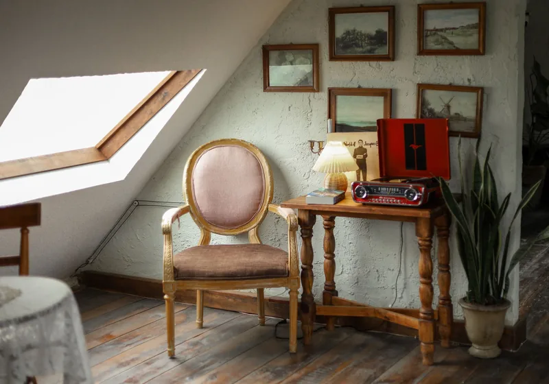 Dachkammer mit Sessel, gerahmten Bildern und persönlichen Dingen vor einer Nachlassauflösung