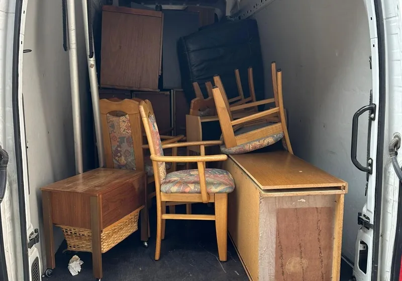 Transporter mit Kommode, Stühlen und Truhe beladen